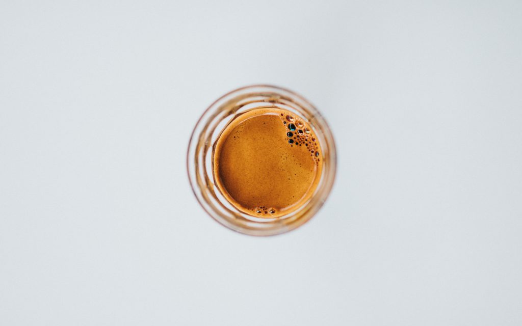 A single shot of espresso in a glass.