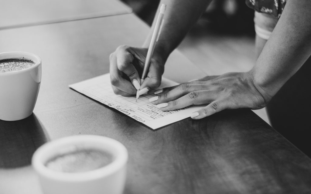 A coffee professional uses a cupping form.