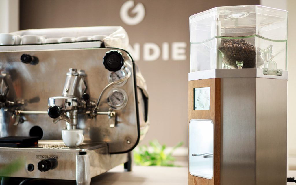 A Grindie coffee grinder next to an espresso machine.
