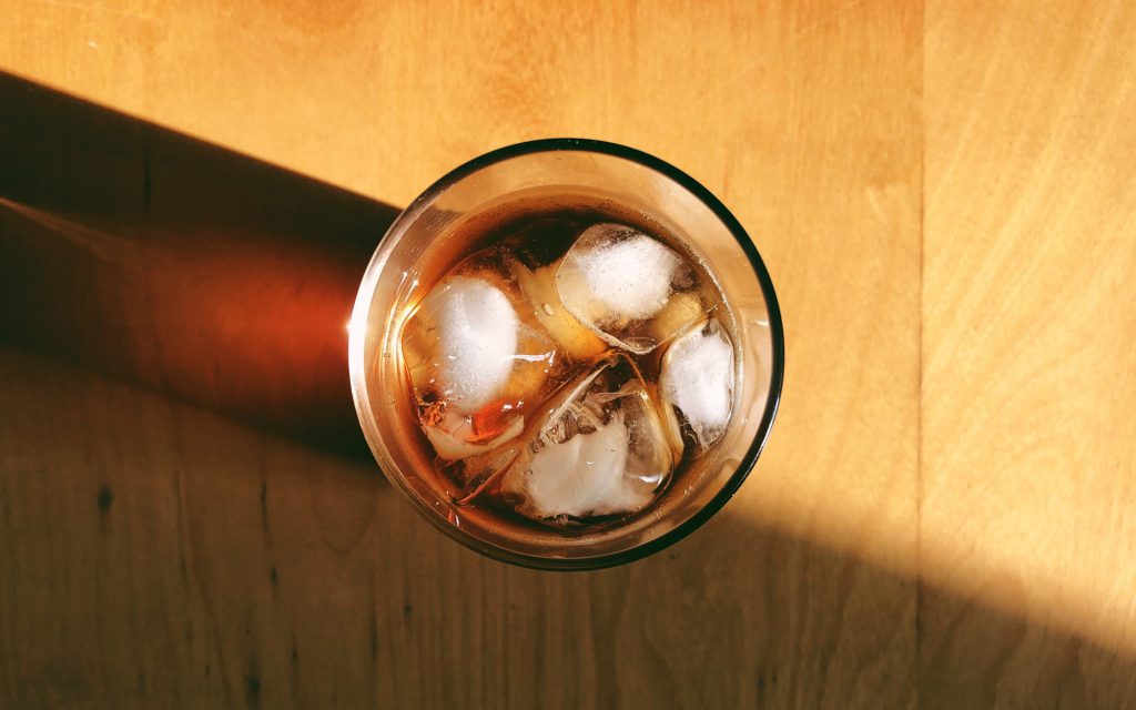 A glass of cold coffee with ice cubes.