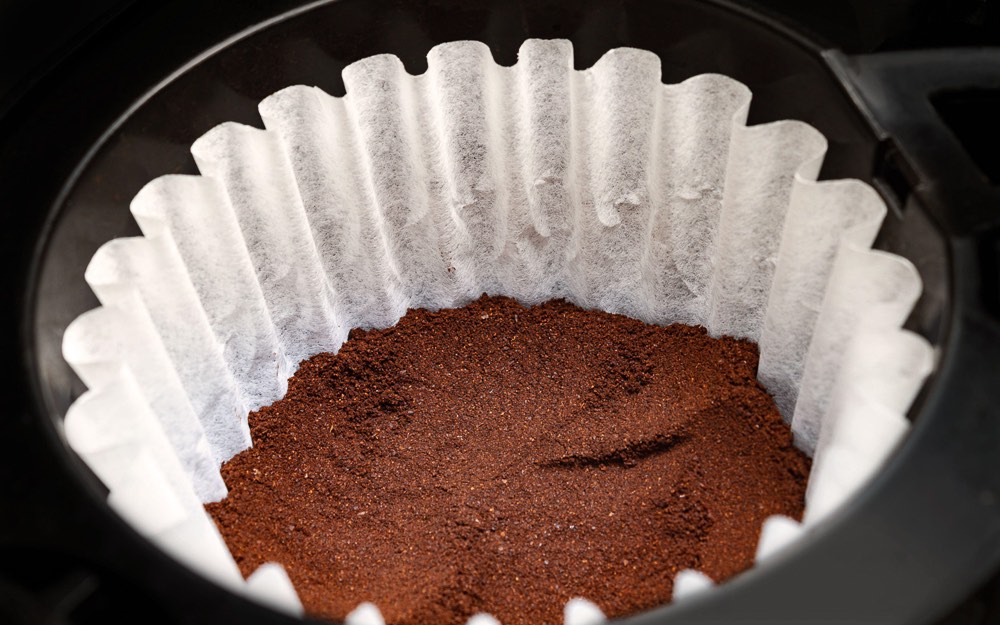Ground coffee in a batch brew filter basket.