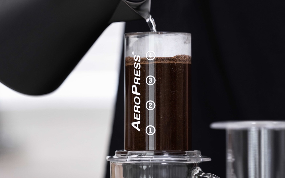 Brewing coffee using a clear AeroPress brewer.