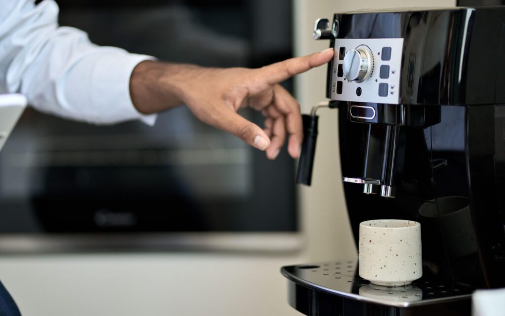 A person selects a drink on a fully-automatic espresso machine.