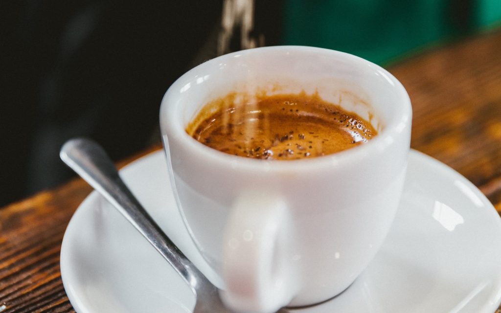 A shot of espresso in a small white cup.