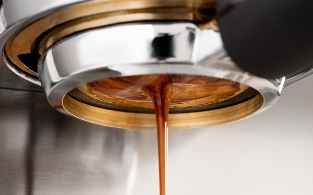 Coffee pours out of a bottomless portafilter.