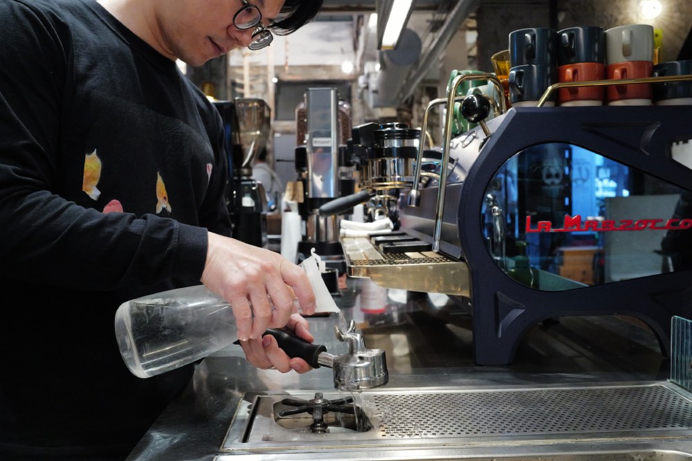 2016 World Barista Champion Berg Wu pours ice cold water over a portafilter.