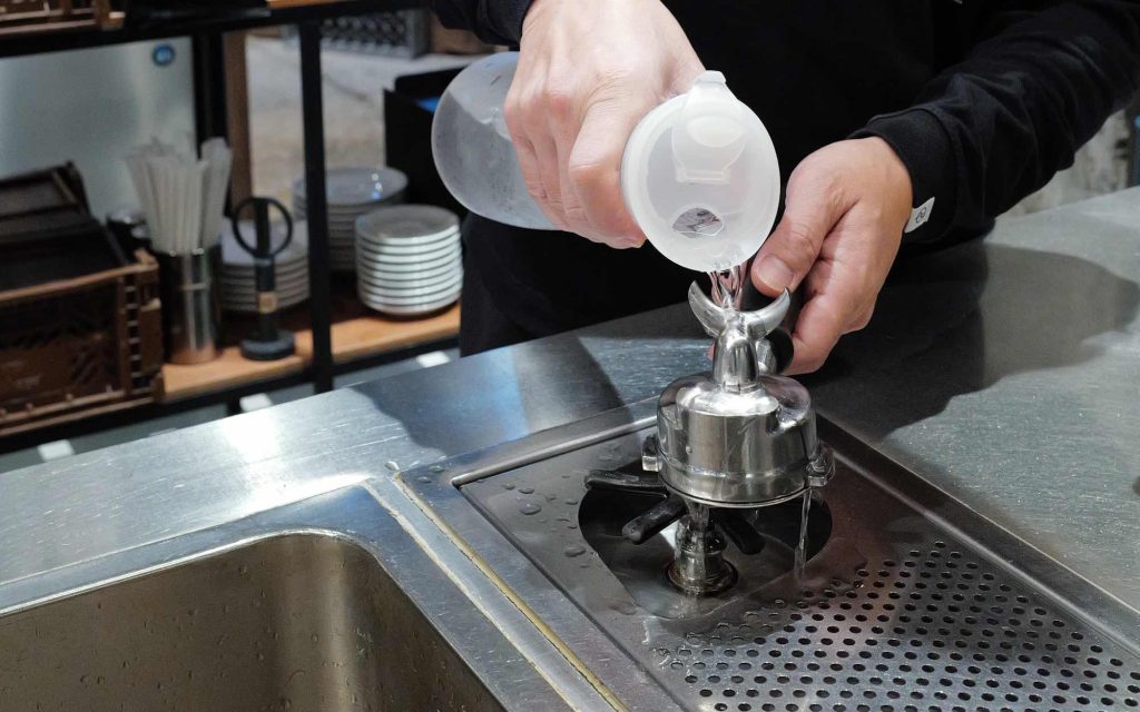 Chee Lu uses cold water to rapidly chill an espresso portafilter.