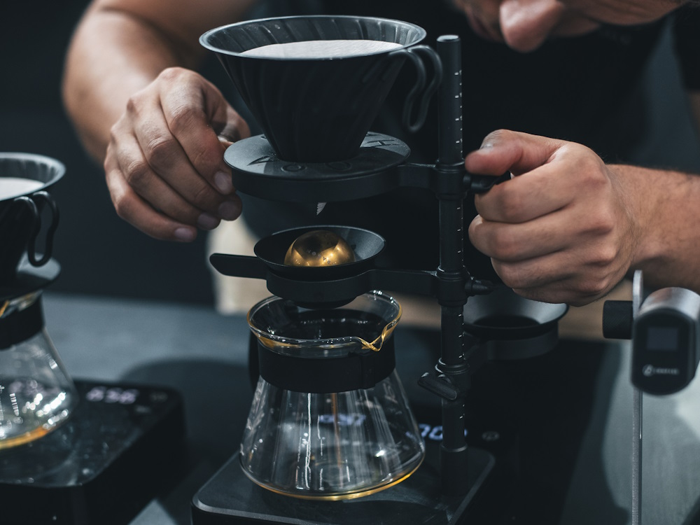 A barista uses the Nucleus Coffee Tools Paragon cooling ball.